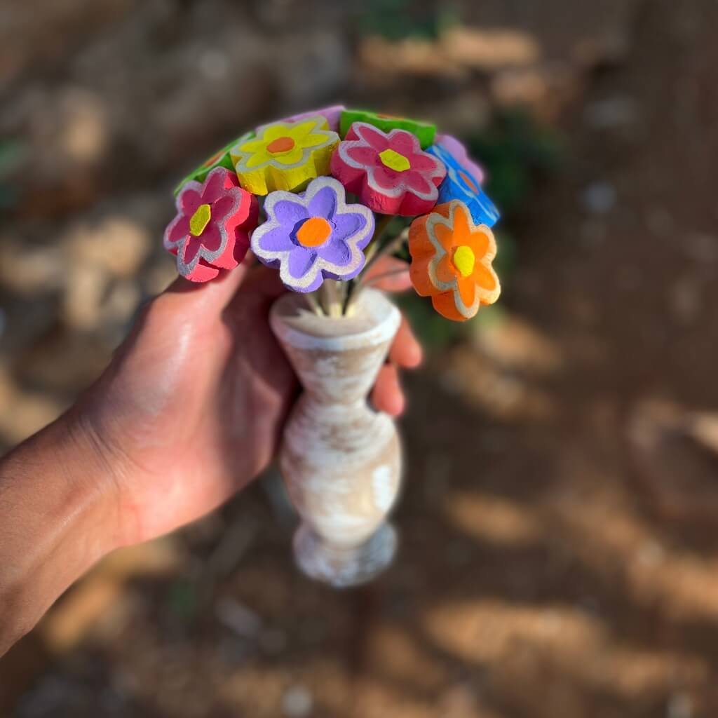 "Vaso de flores de madeira sendo segurada"