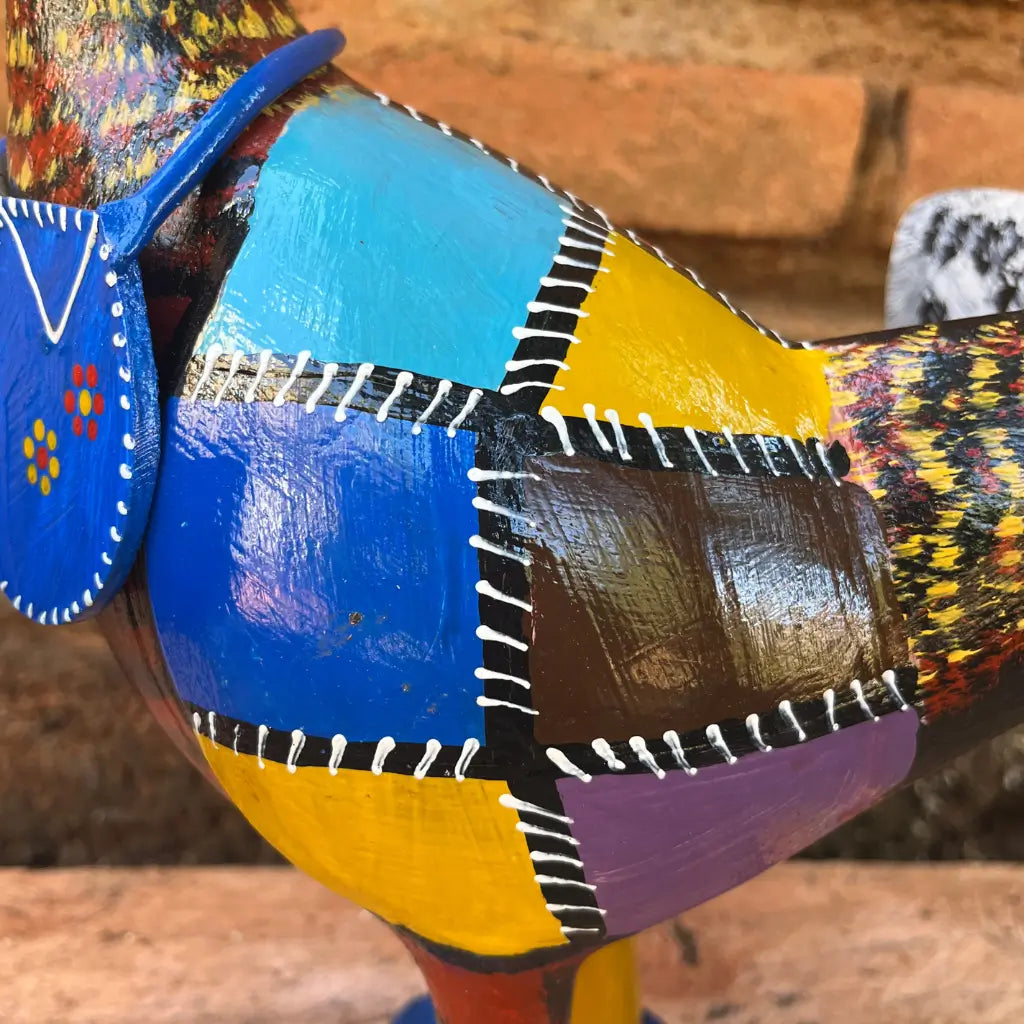 "Detalhes da pintura em patchwork na galinha caipira feita de madeira"