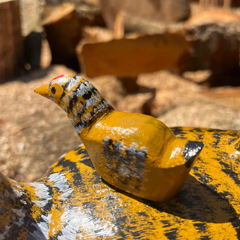 "Detalhes do pintinho em cima da galinha de ninho amarela feitos de madeira"