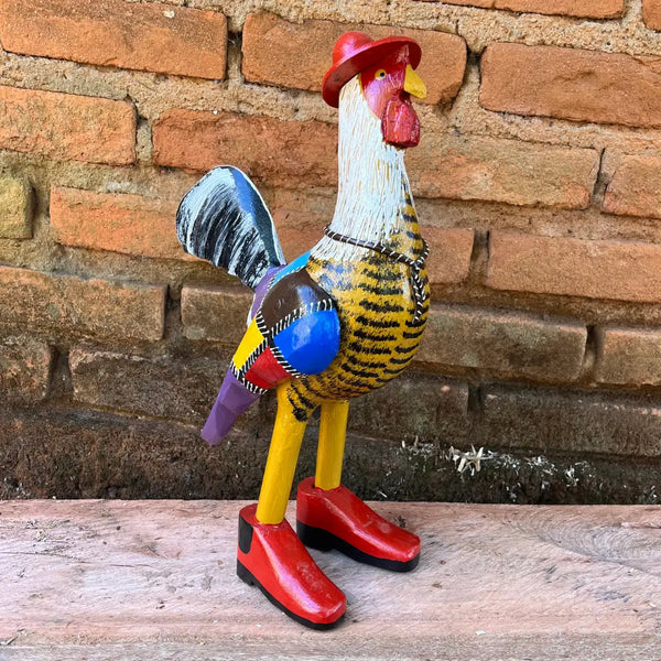 "Uma escultura de galo caipira com bota chapéu e gravata amarelo com pintura patchwork"