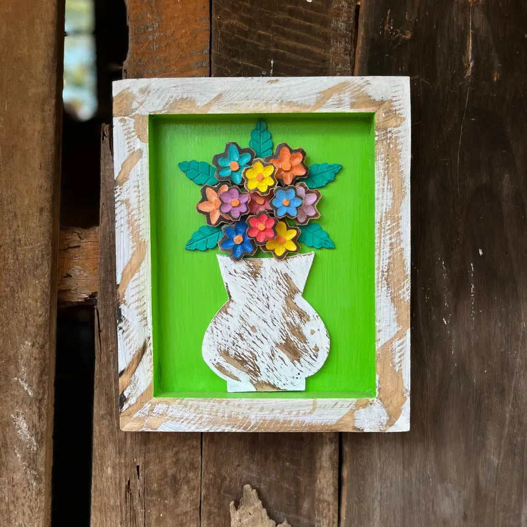 "Um quadro de parede feito de madeira com vaso de flores"