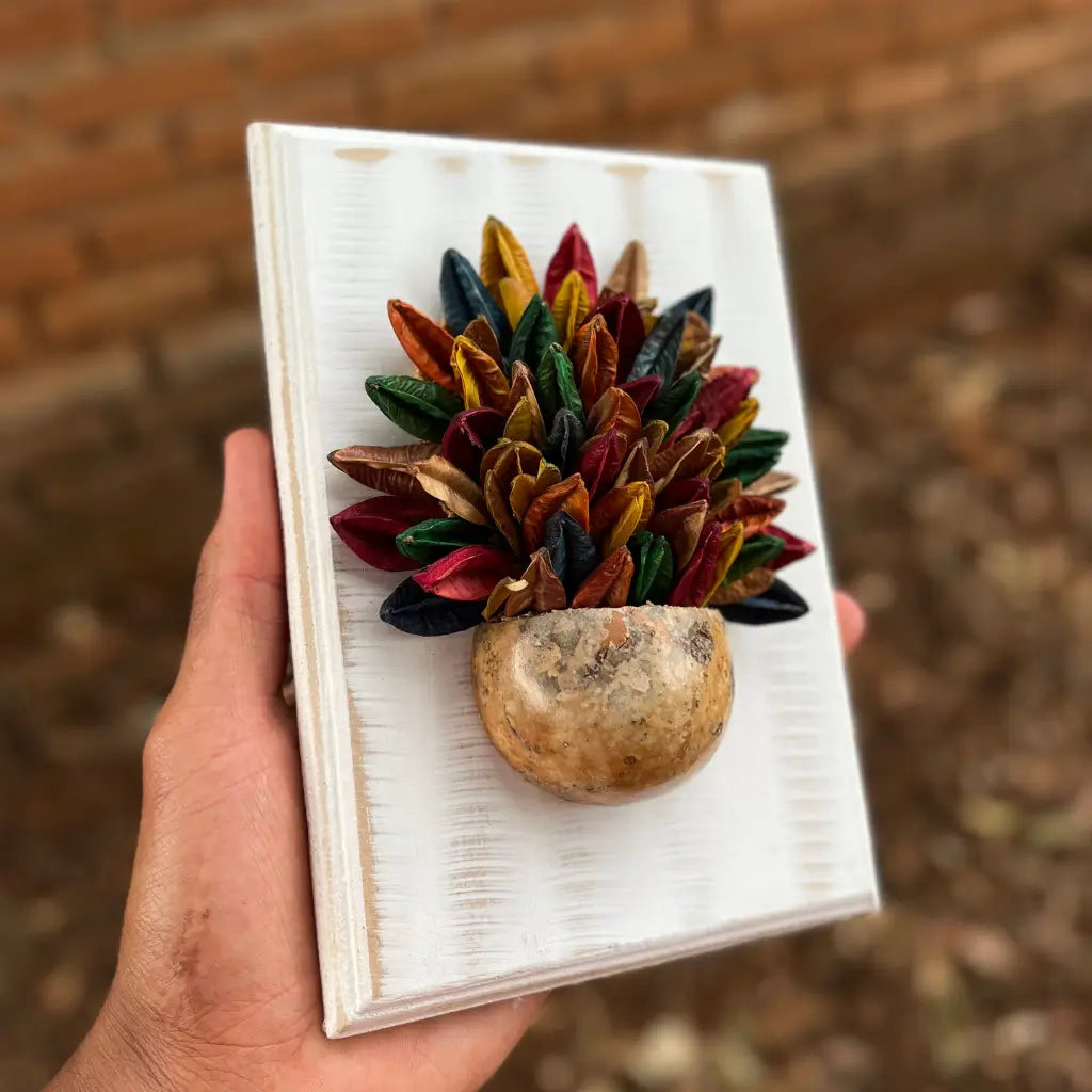 "Um quadro de parede com vaso de sementes sendo segurado nas mãos"